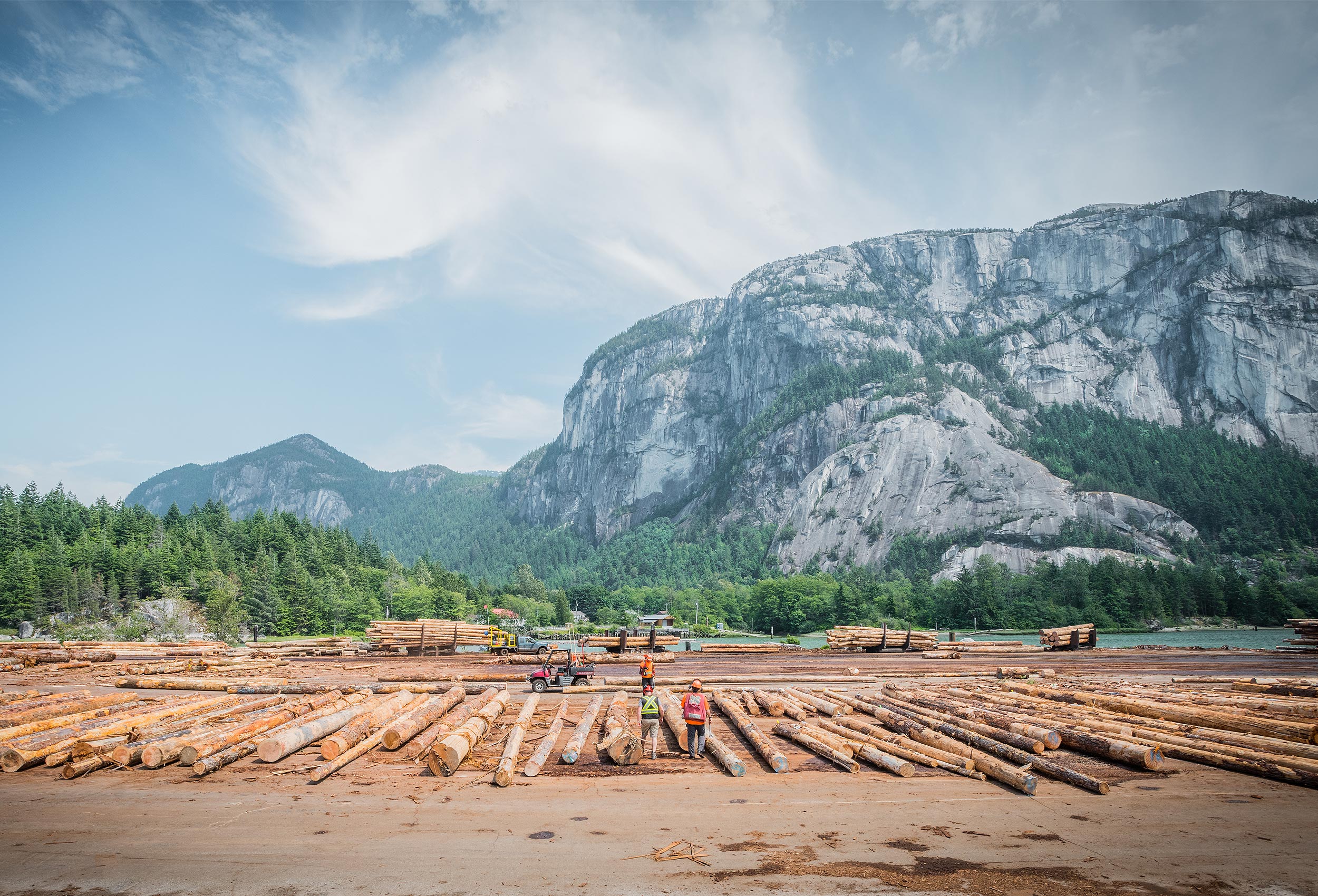 Worker cutting log at sorting facility in Squamish, BC by corporate  industrial photographer Kristopher Grunert. 